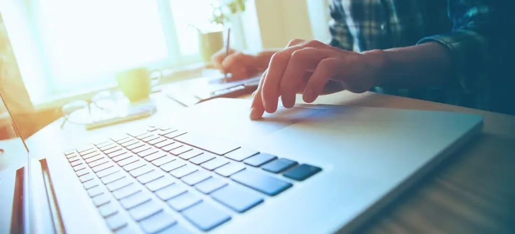 Close up of hands typing on a laptop